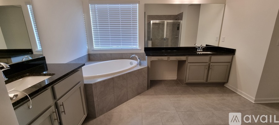 A bathroom with a tub, sink, and mirror.