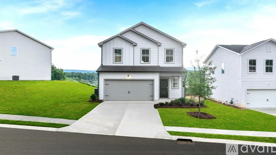 A white house with a garage is available for sale.