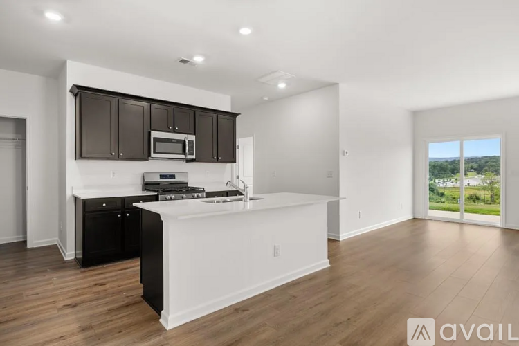 A modern kitchen with black cabinets and a white island.