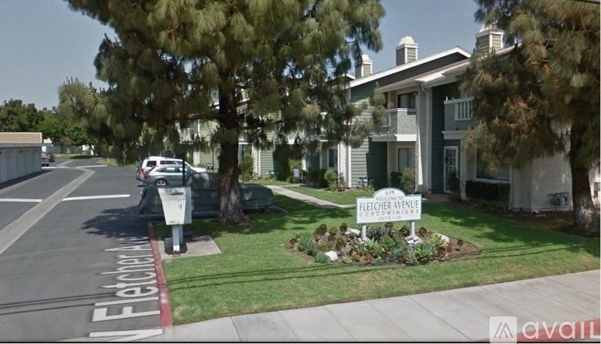 A street view of Fletcher Avenue with a house and trees.
