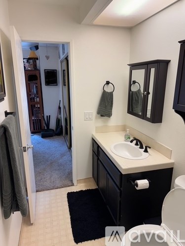 A bathroom with a sink, toilet, and a mirror.