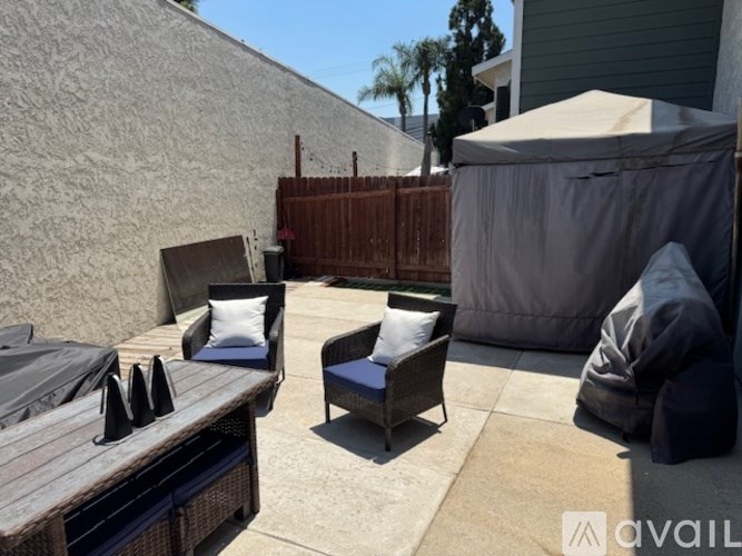 A patio with a table, chairs, and an umbrella.