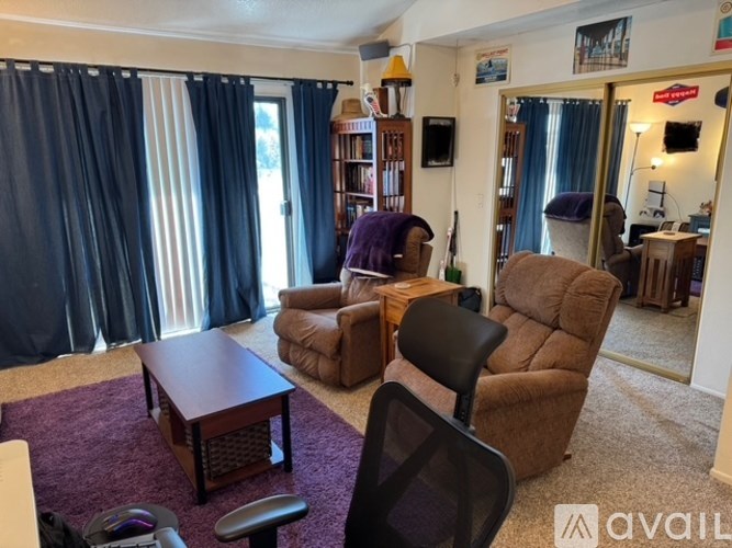 A living room with a brown couch, a brown chair, and a wooden coffee table.