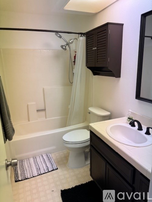 A bathroom with a toilet, sink, and bathtub.