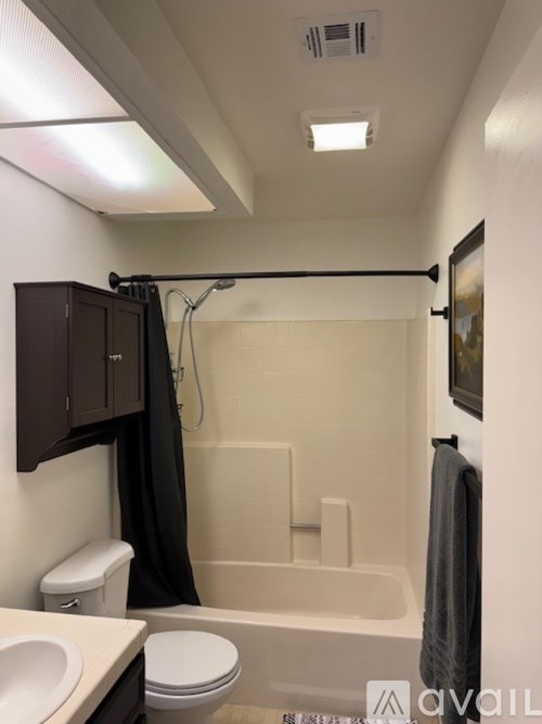 A bathroom with a toilet, sink, and bathtub.