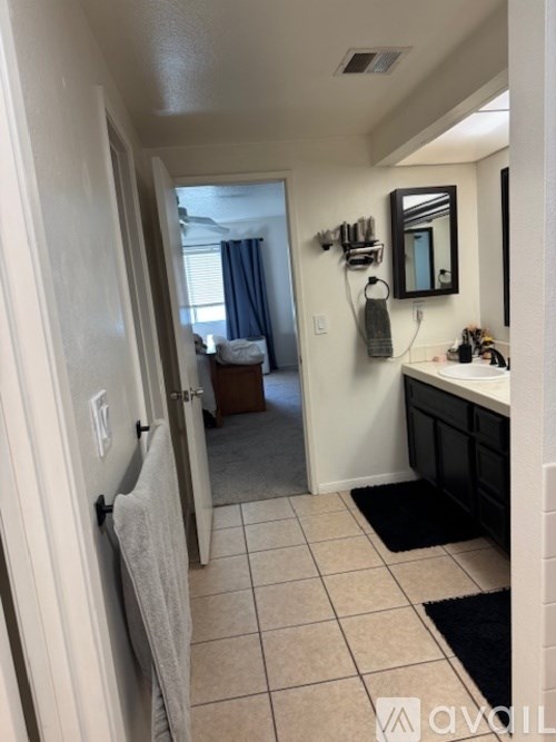 A bathroom with a white door, sink, and mirror.