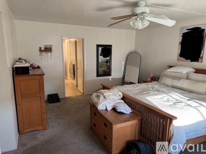 A bedroom with a bed, dresser, and mirror.