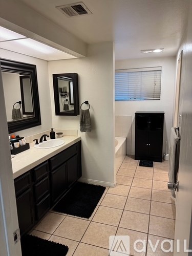 A bathroom with a sink, mirror, and towel rack.
