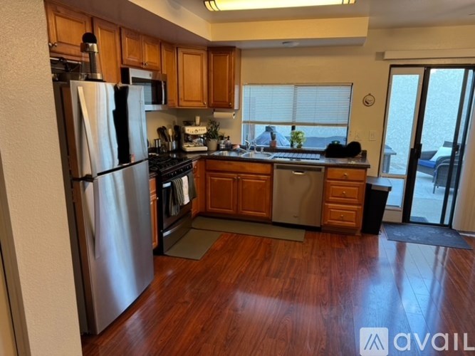 A kitchen with wooden cabinets and a refrigerator.
