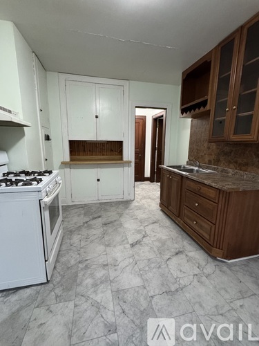 A kitchen with wooden cabinets and a marble countertop.