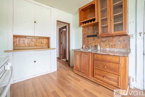 A kitchen with wooden cabinets and a marble countertop.