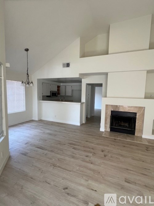 A living room with a fireplace and a staircase.