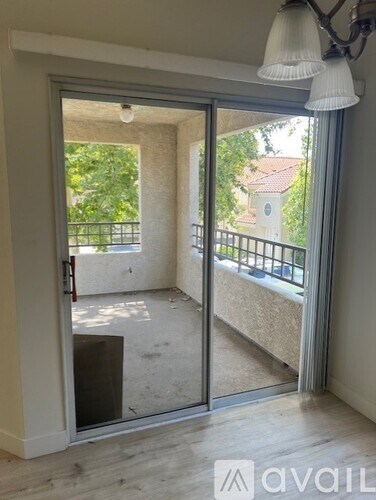 A room with a sliding glass door leading to a balcony.