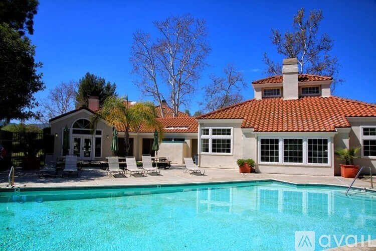 A large house with a pool in front.
