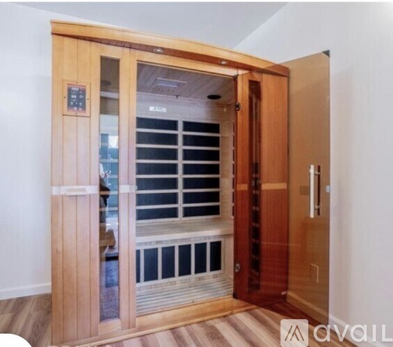 A wooden door with a glass window and a control panel on the left side.