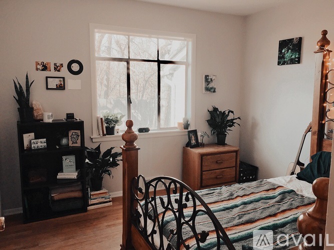 A bedroom with a bed, dresser, and window.