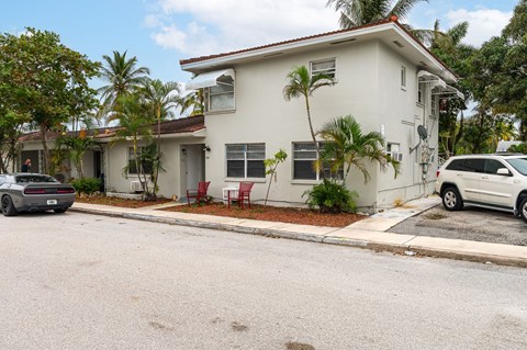 A white house with a red chair in front of it.