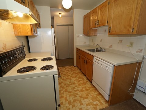 A kitchen with a white stove and a white dishwasher.