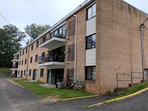 A brick building with a balcony on the second floor.
