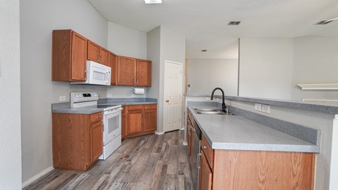 A kitchen with wooden cabinets and a white fridge.