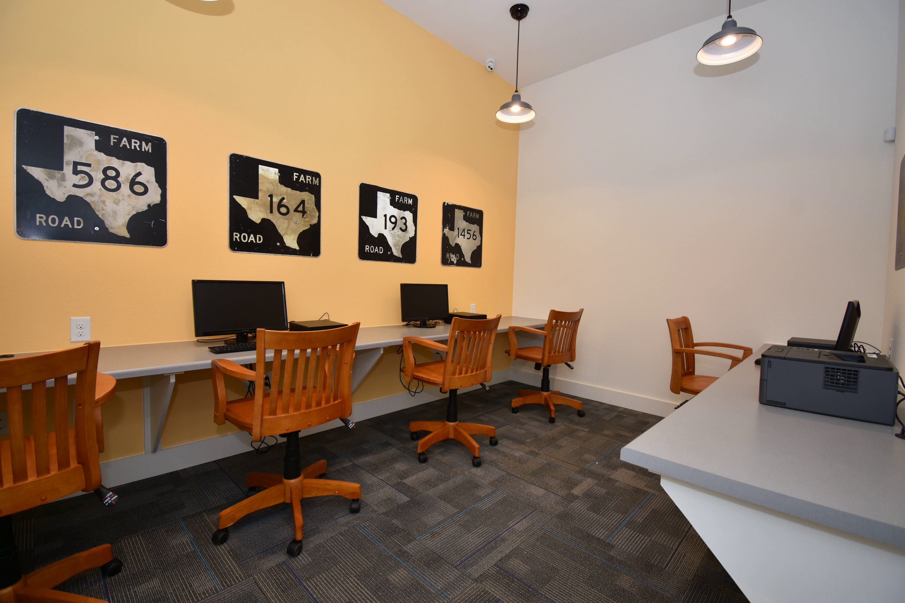 A conference room with a white table and chairs and a wall with signs that say Farm Road 586, Farm Road 164, and Farm Road 193.