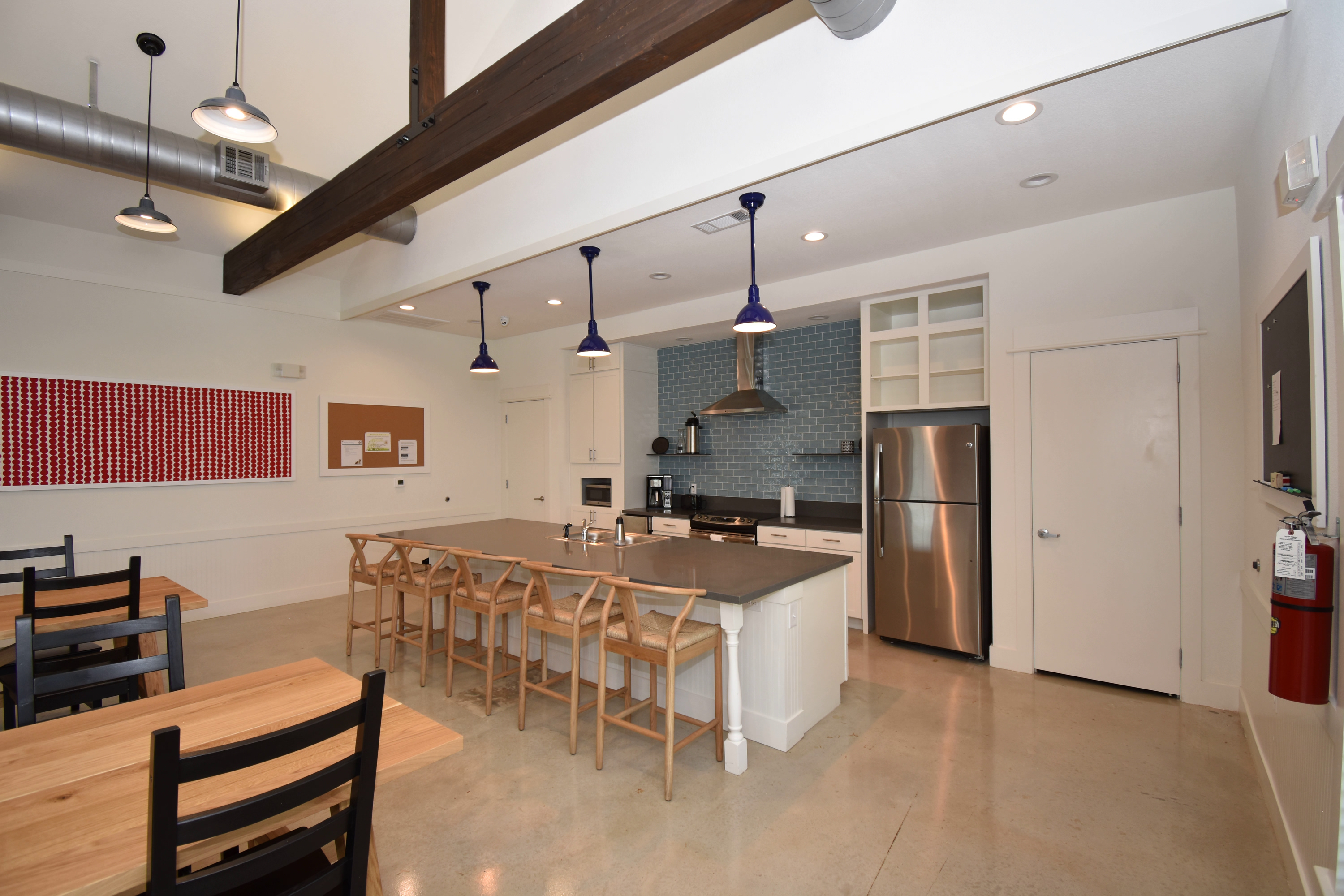 A kitchen with a long table and chairs.