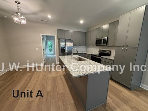 A kitchen with wooden floors and a white ceiling.