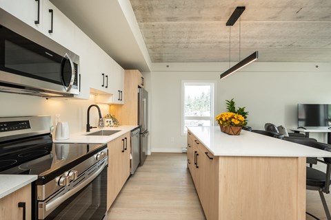 A modern kitchen with wooden cabinets and black appliances.