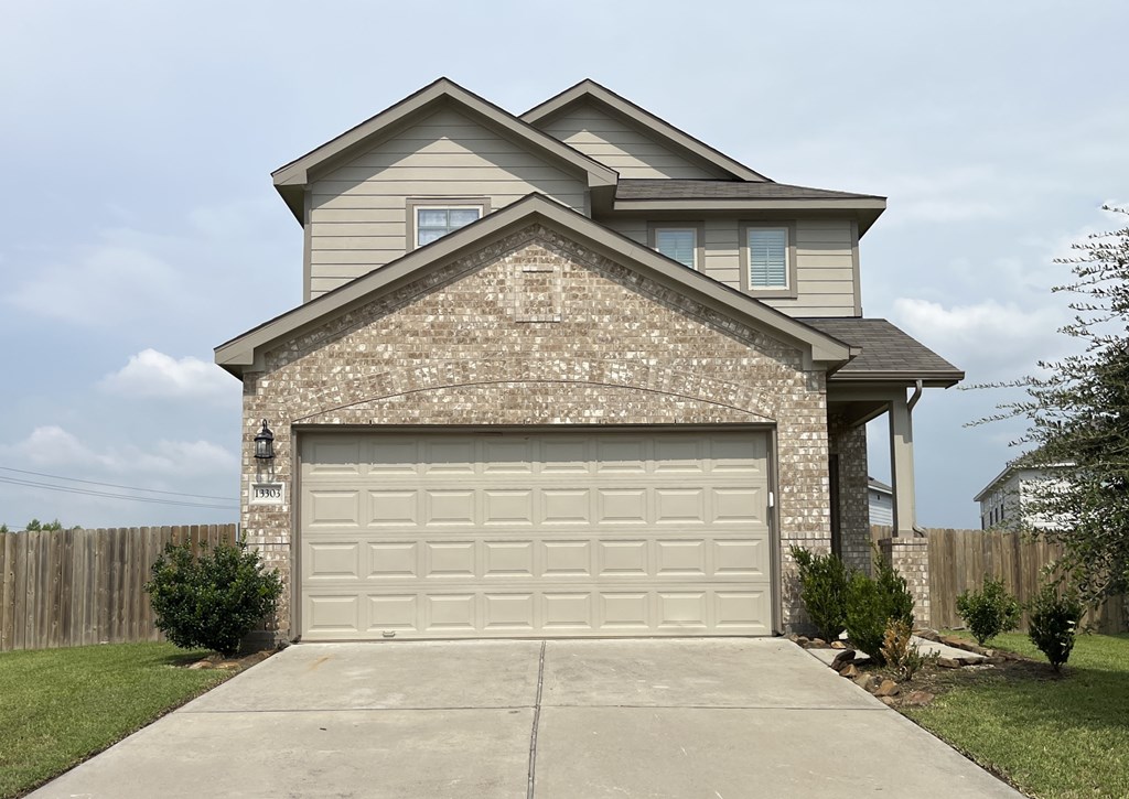 A two-story house with a garage door.