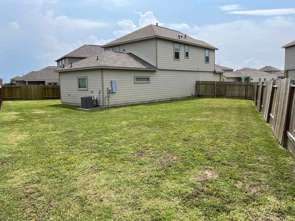 A house with a fenced yard in front.