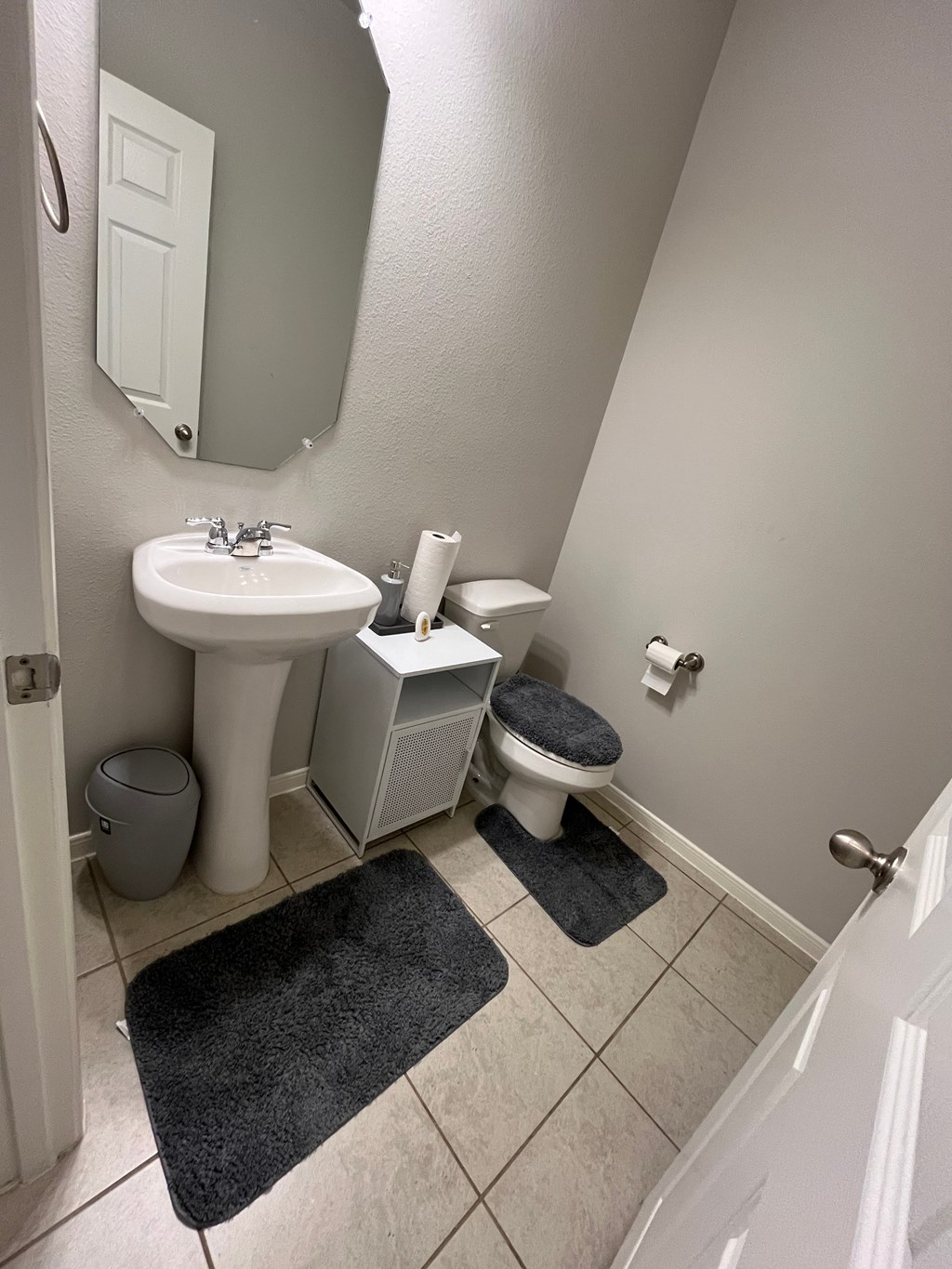 A bathroom with a toilet, sink, and mirror.