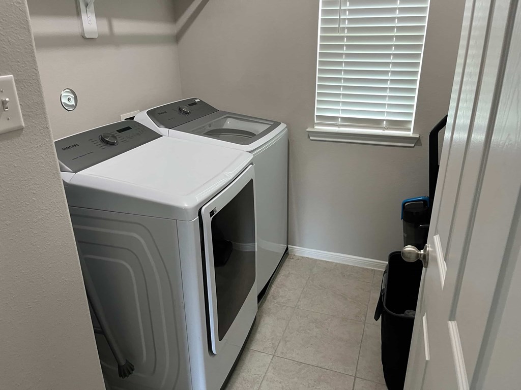 A small laundry room with a washer and dryer.