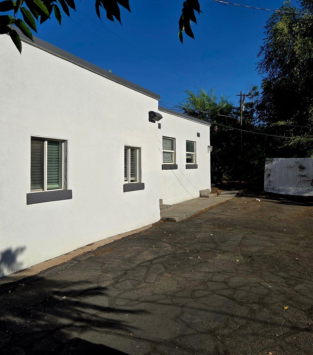 A white building with a grey roof and a grey door.