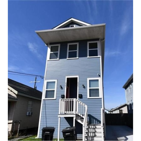 A two-story house with a balcony and a staircase leading to the second floor.