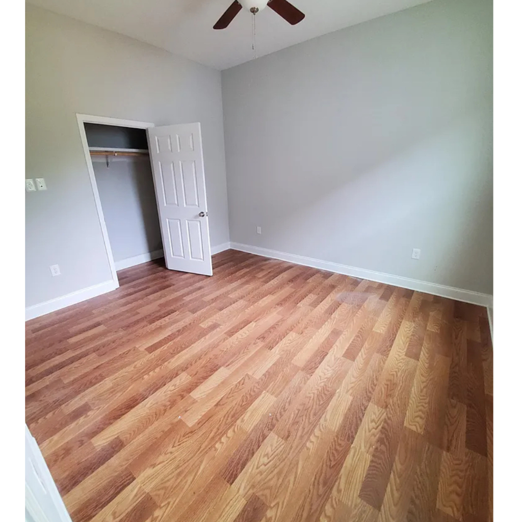 A room with a wood floor and a ceiling fan.