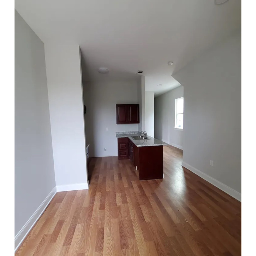 A kitchen with wooden floors and white walls.