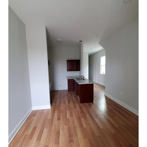 A kitchen with wooden floors and white walls.
