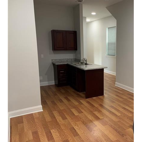 A kitchen with wooden floors and a counter.