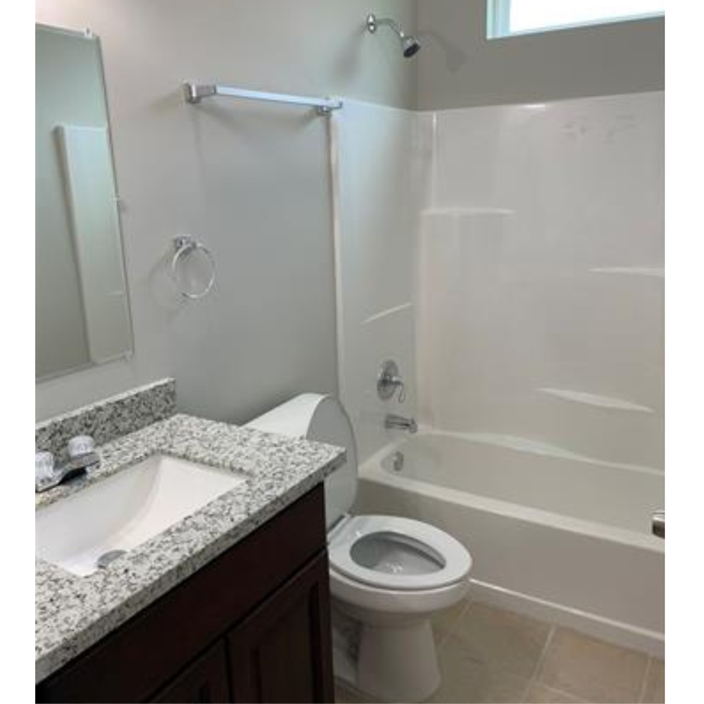 A white toilet is next to a white bathtub in a bathroom.
