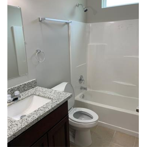 A white toilet is next to a white bathtub in a bathroom.