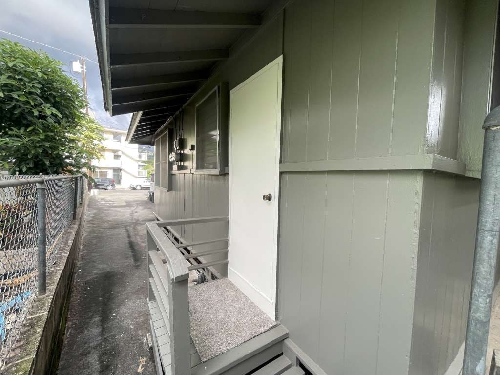 A long, narrow building with a white door and a grey roof.