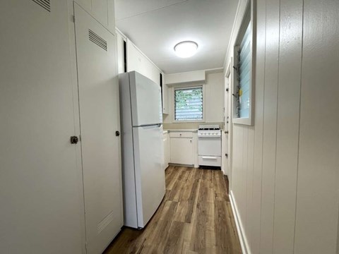 A small kitchen with a refrigerator and a stove top oven.