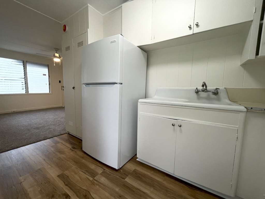 A white refrigerator and sink in a kitchen.