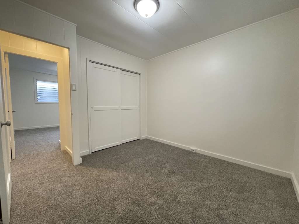 A room with a carpeted floor and a white door.