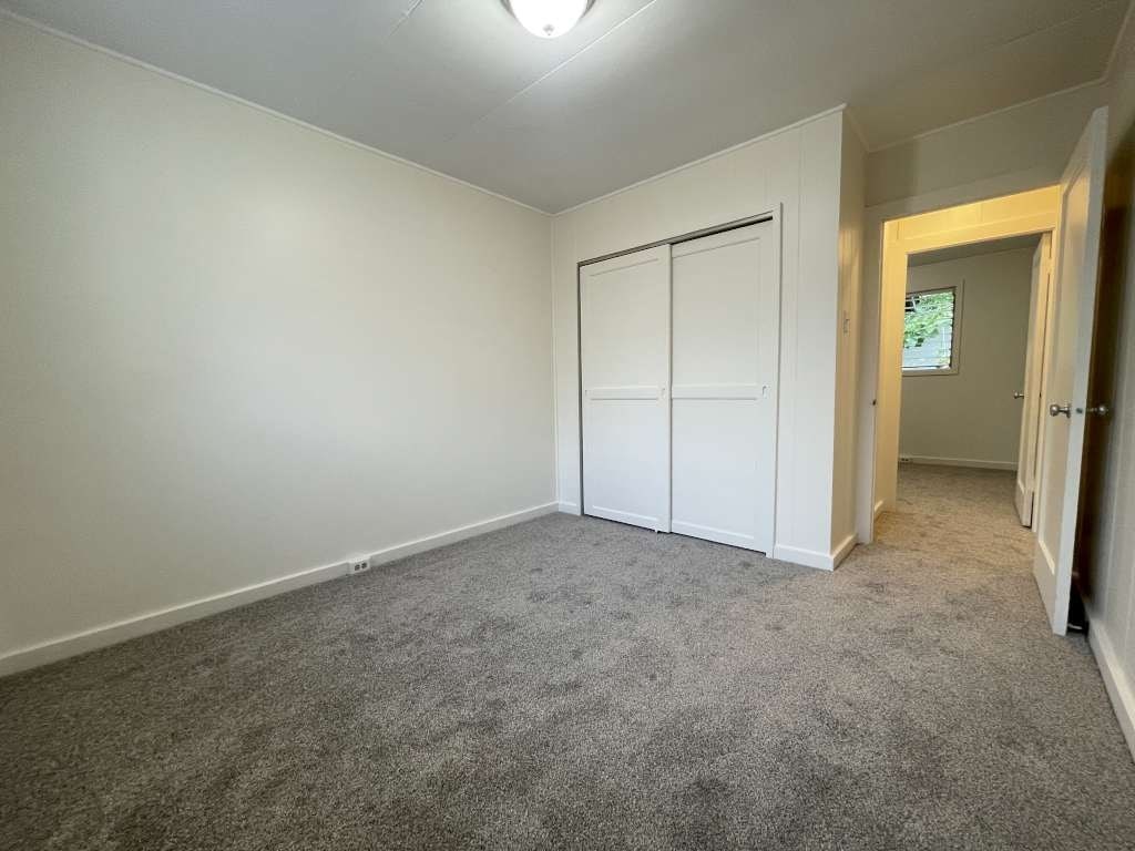 A room with a grey carpet and white walls.