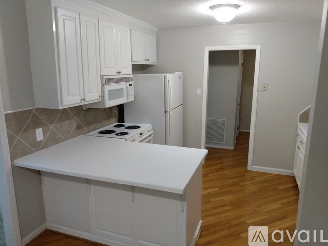 A kitchen with white cabinets and a white countertop.