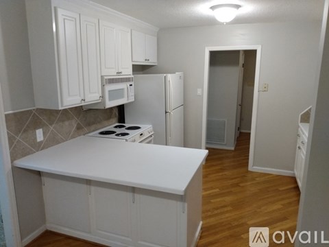 A kitchen with white cabinets and a white countertop.