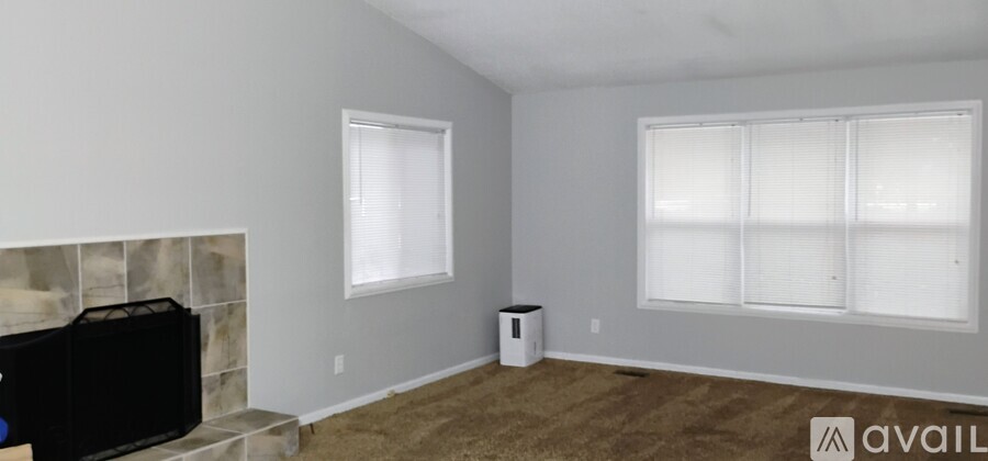A living room with a fireplace and a large window.