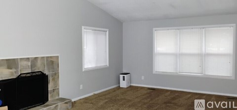 A living room with a fireplace and a large window.