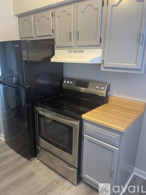 A kitchen with a black fridge, stove and oven.